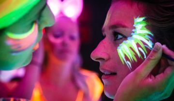 close-up van glow in the dark schmink tijdens het themafeest personeelsfeest.